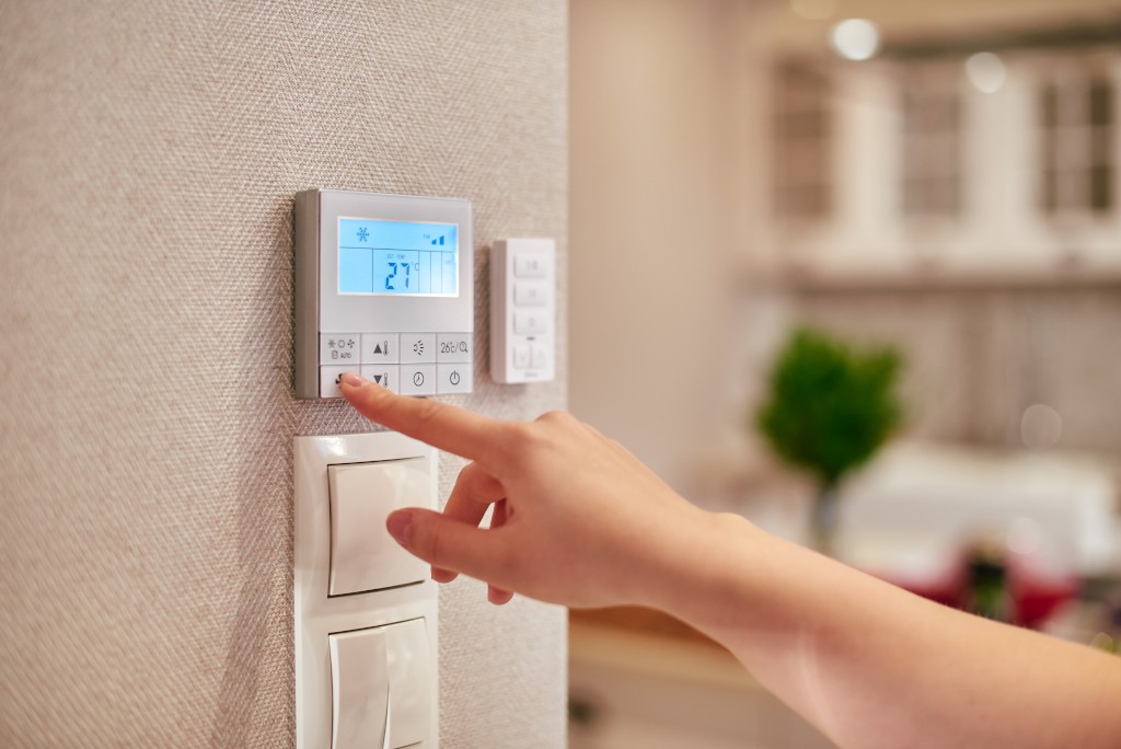 Woman programming temperature inside home