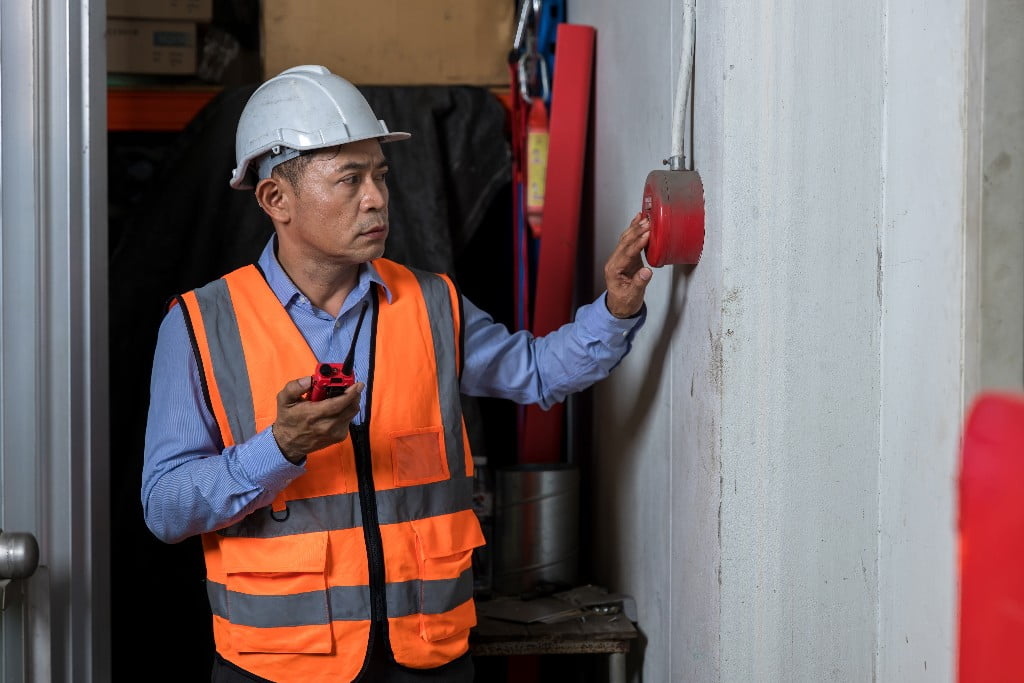 foreman-or-worker-pushing-fire-alarm-on-the-wall-2023-11-27-05-11-46-utc Inspecting a Fire Alarm in Philadelphia for Alarm Certification